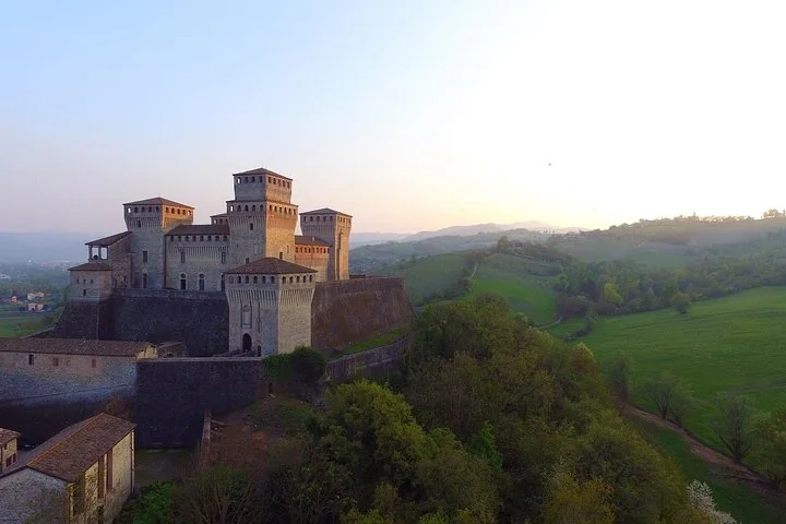 Il Castello di Torrechiara sulla sua collina al crepuscolo, con la valle sottostante